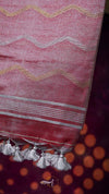 Red fabric with white zigzag pattern and tassels on a dark background
