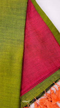 Close-up of green and red fabric with orange tassels on a white background