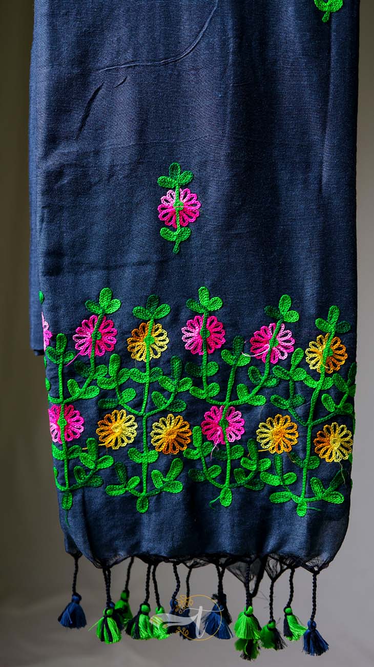 Navy blue fabric with colorful floral embroidery on a gray background
