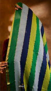 Person holding a colorful striped fabric with green, yellow, blue, and gray stripes.