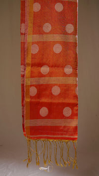 Orange fabric with white polka dots and gold trim on a beige background
