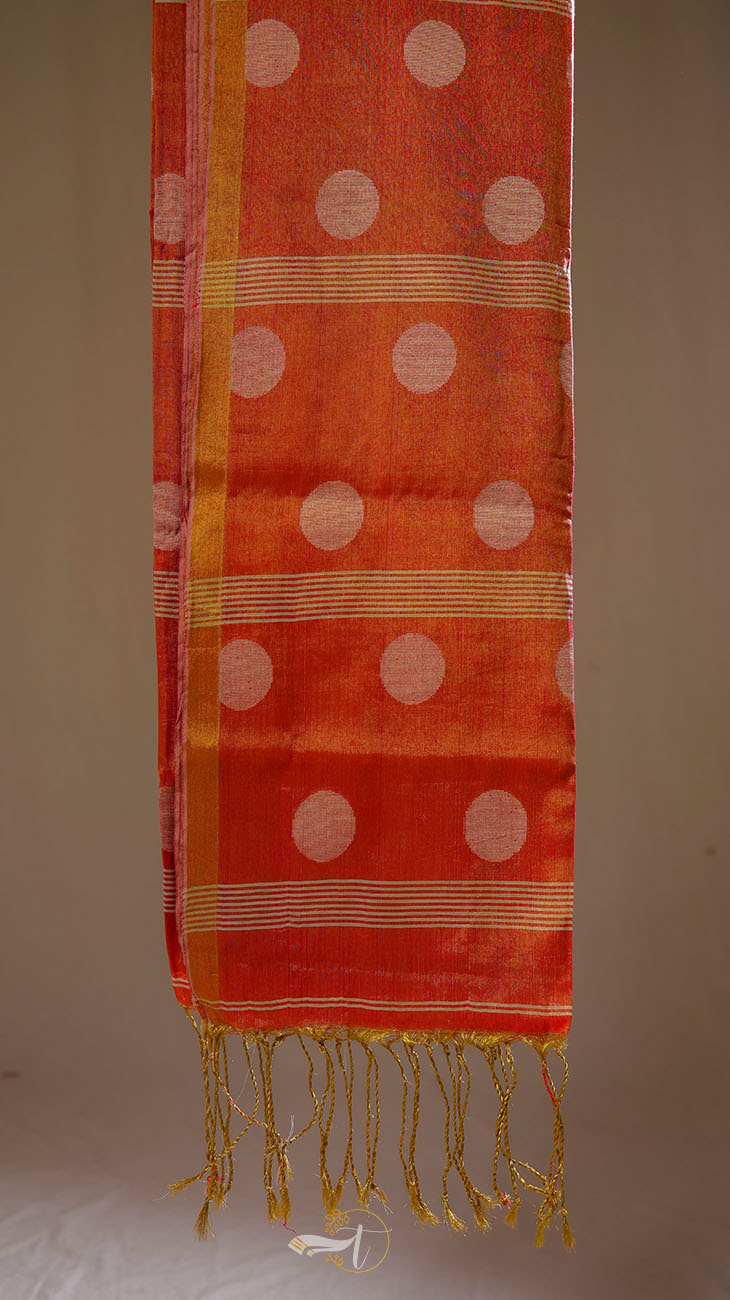 Orange fabric with white polka dots and gold trim on a beige background