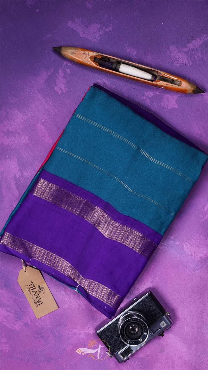 Purple and teal saree with a camera and loom on a purple background