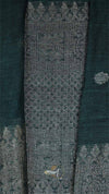 Textured fabric with intricate patterns and a brand logo on a dark background