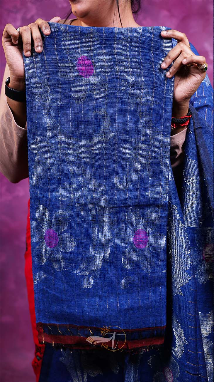 Person holding a blue floral patterned fabric against a purple background