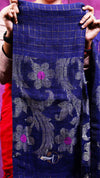 Person holding a blue fabric with floral patterns against a purple background