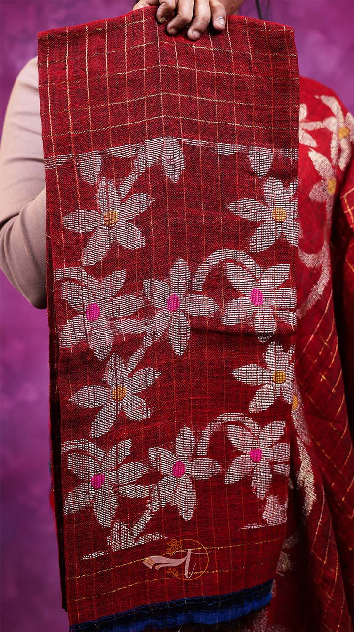Red fabric with floral patterns held by a person against a purple background