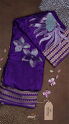 Purple fabric with floral embroidery on a brown background