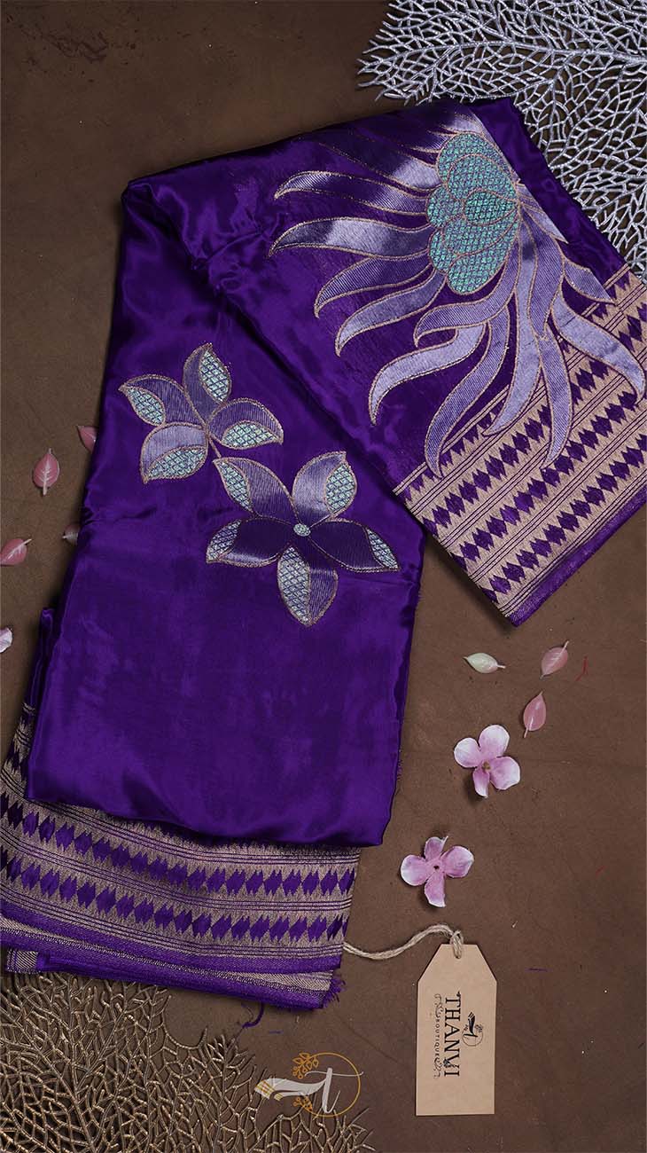 Purple fabric with floral embroidery on a brown background