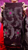 Person holding a floral patterned fabric with a purple background