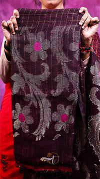 Person holding a floral patterned fabric with a purple background