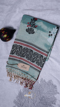 Teal towel with floral and elephant patterns on a textured surface