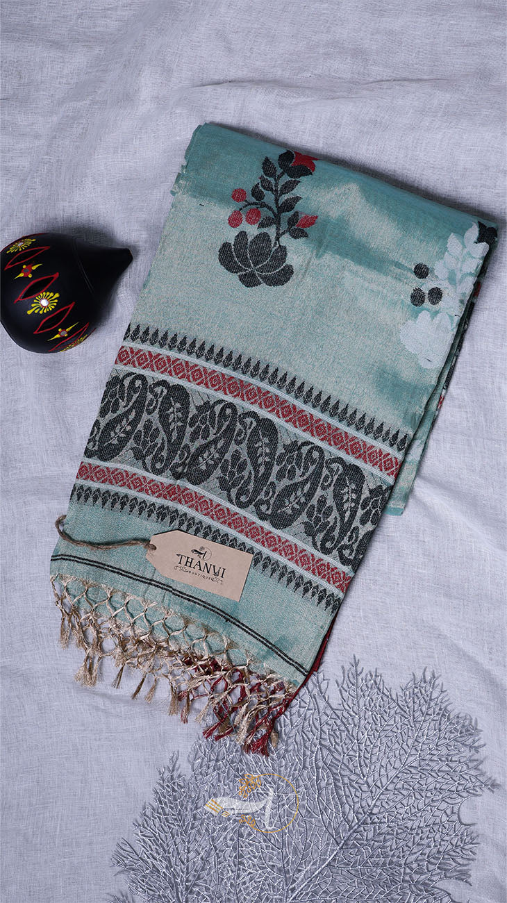 Teal towel with floral and elephant patterns on a textured surface