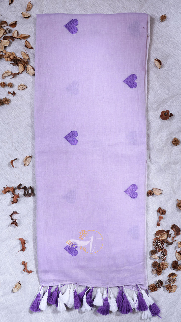 Lavender towel with purple hearts and tassels on a textured surface