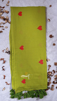 Green scarf with red heart patterns on a textured white background