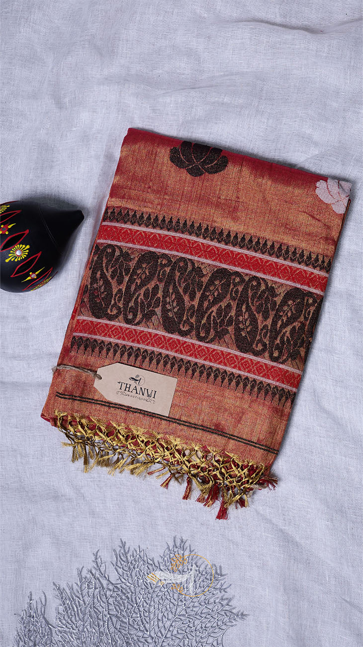 Decorative red and brown patterned scarf with gold fringe on a light gray background