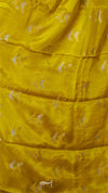 Close-up of a yellow quilt with subtle patterns on a plain background