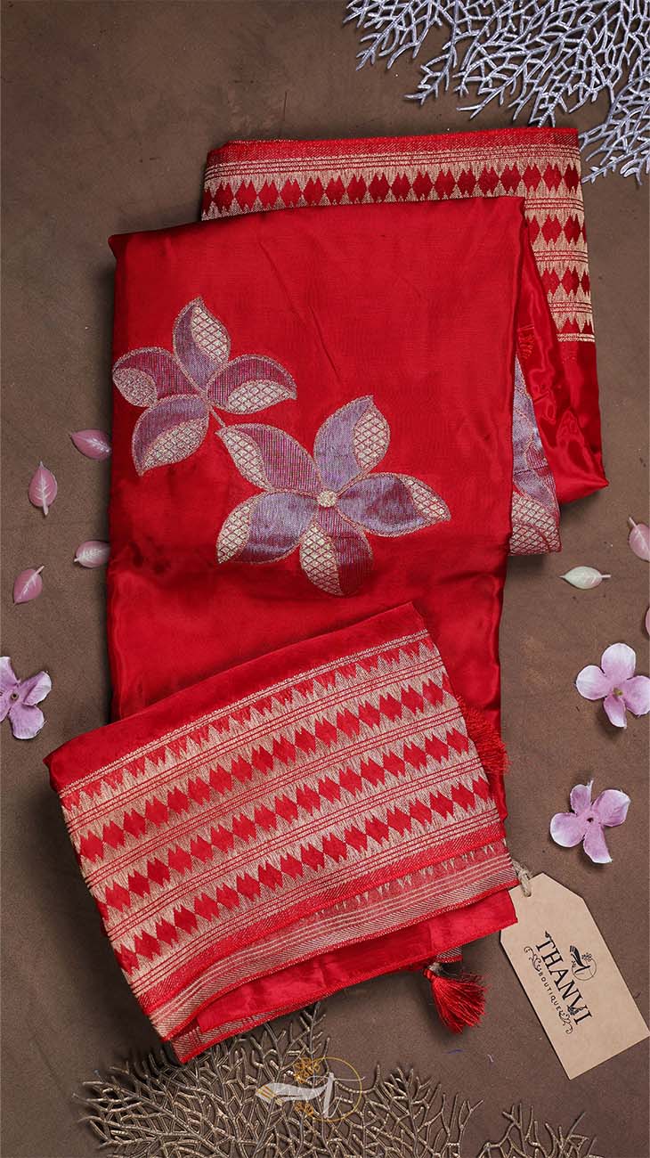 Red fabric with floral embroidery on a brown surface with decorative elements.