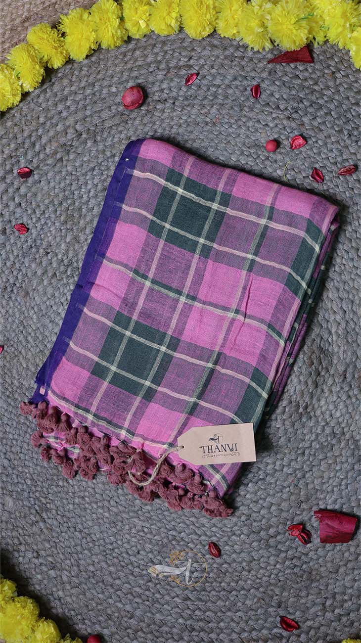 Plaid towel with purple and green pattern on a textured surface with decorative elements.