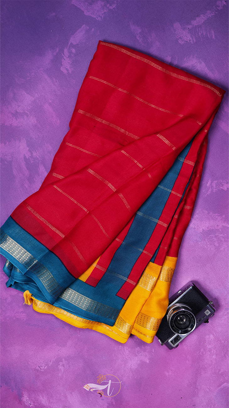 Red, blue, and yellow saree with a camera on a purple background