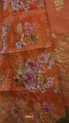 Close-up of orange fabric with floral embroidery