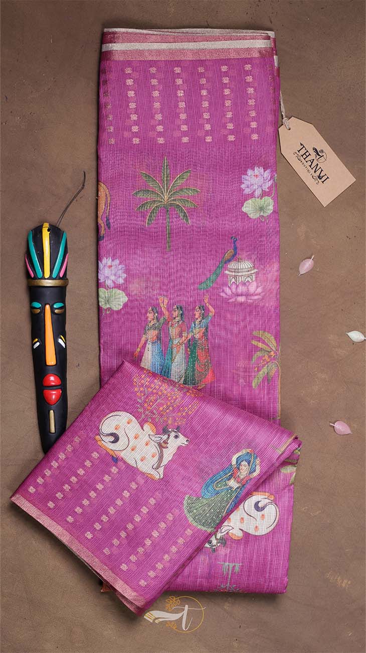 Pink embroidered fabric with traditional designs on a brown background
