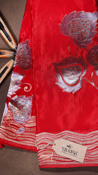Red fabric with silver floral patterns and a 'THANVI' tag on a brown background
