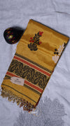 Yellow scarf with intricate patterns on a light gray background