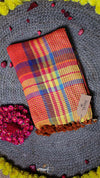 Colorful plaid fabric with a tag on a textured surface