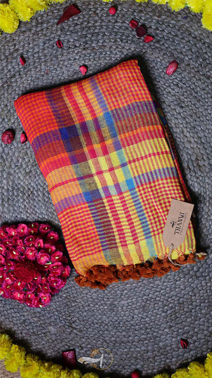 Colorful plaid fabric with a tag on a textured surface