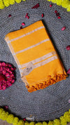 Yellow fabric with white stripes on a textured gray surface with pink and yellow flowers.