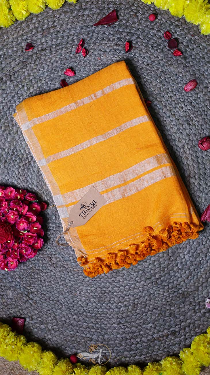 Yellow fabric with white stripes on a textured gray surface with pink and yellow flowers.