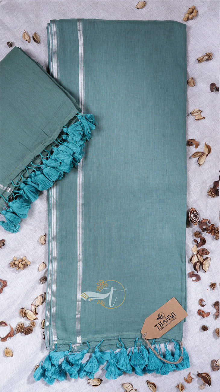 Teal towel with ruffled edges on a textured surface