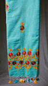 Turquoise fabric with colorful floral embroidery on a plain background