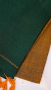 Close-up of green and brown fabric with orange tassels on a white background
