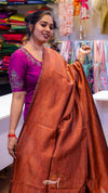 Woman wearing a pink blouse with a brown saree in a store setting