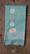 Teal scarf with floral patterns and fringes on a brown background