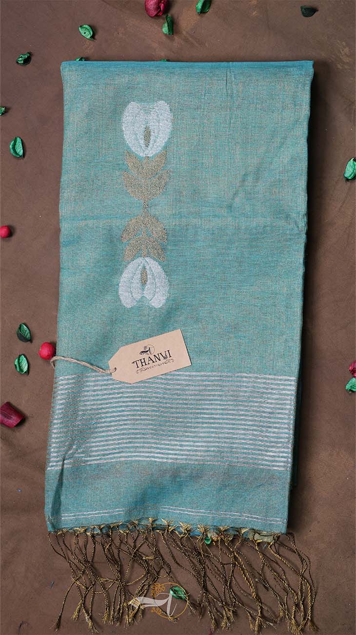 Teal scarf with floral patterns and fringes on a brown background