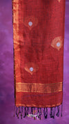 Red fabric with gold patterns and black tassels on a purple background