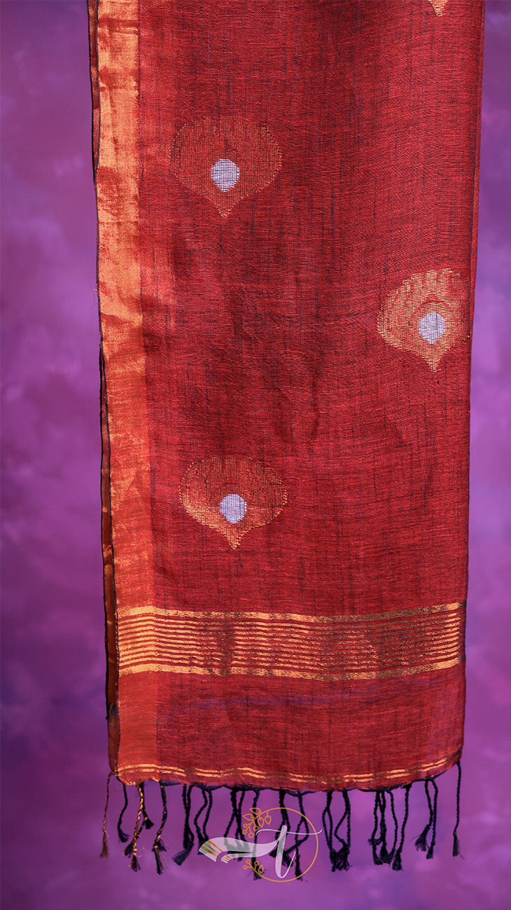 Red fabric with gold patterns and black tassels on a purple background