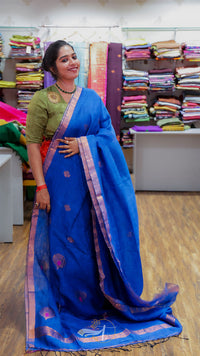 Woman wearing a blue saree with a green blouse in a store setting