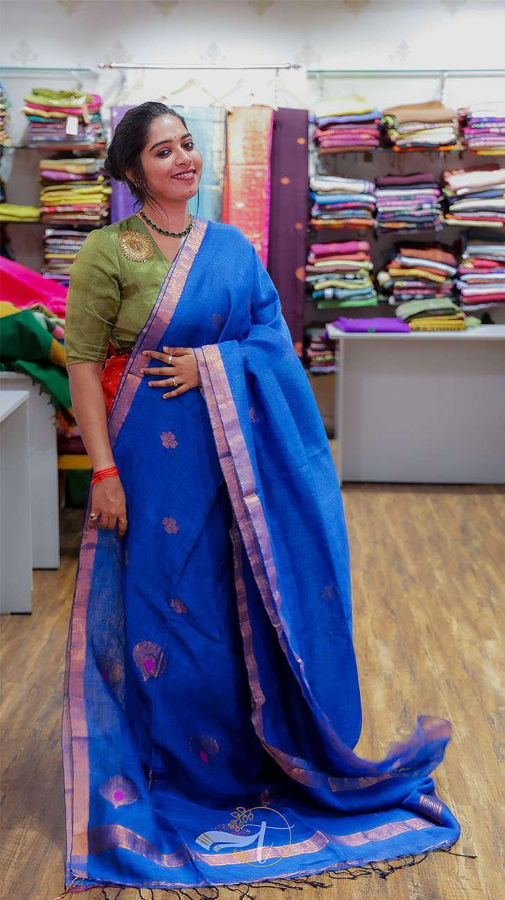 Woman wearing a blue saree with a green blouse in a store setting