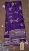 Purple fabric with silver floral and bird patterns on a brown background