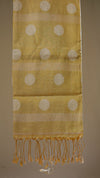 Yellow fabric with white circular patterns and fringes on a brown background