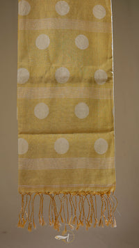 Yellow fabric with white circular patterns and fringes on a brown background