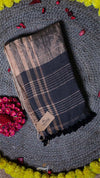 Plaid scarf with brand tag on a textured surface with flowers