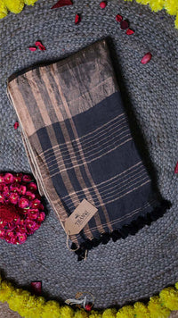 Plaid scarf with brand tag on a textured surface with flowers
