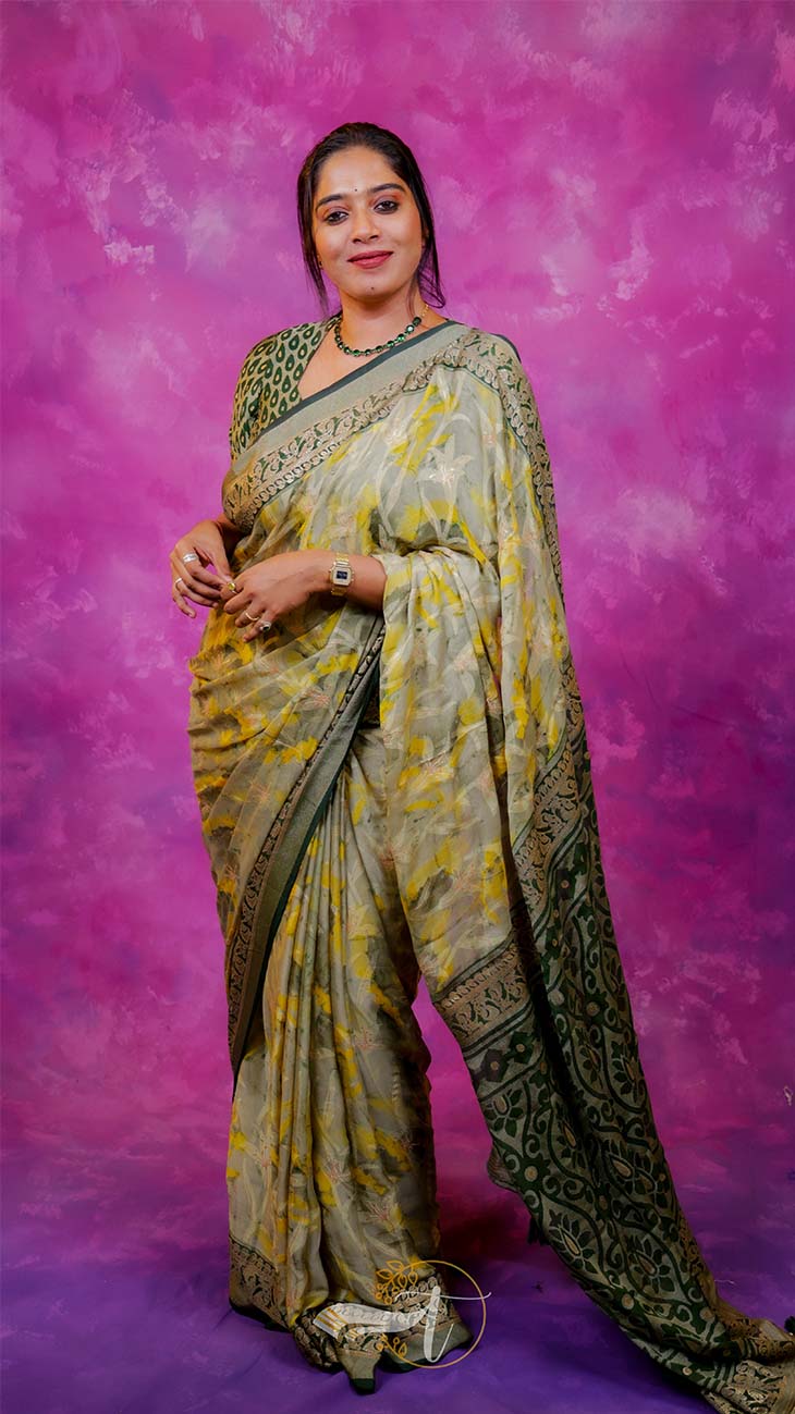 Woman wearing a traditional saree against a pink background