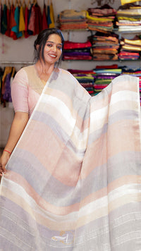 Woman holding a striped saree in a clothing store