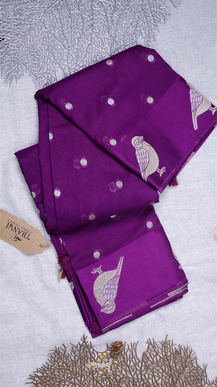 Purple fabric with white bird patterns on a textured gray background